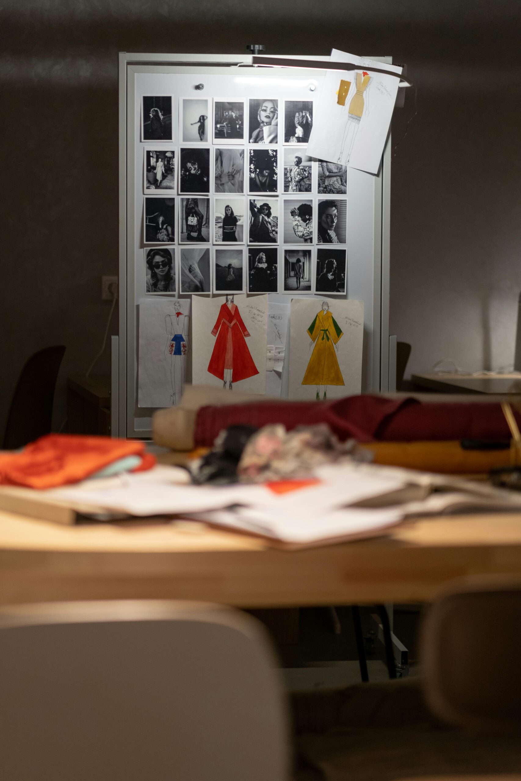 Creative fashion design workspace with sketches and photos, ideal for artistic inspiration.